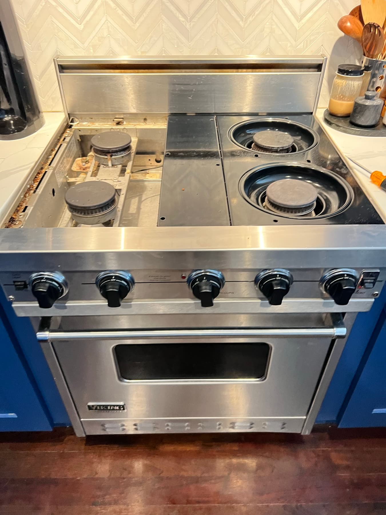 Cooktop with the control panel opened to access internal wiring during repair