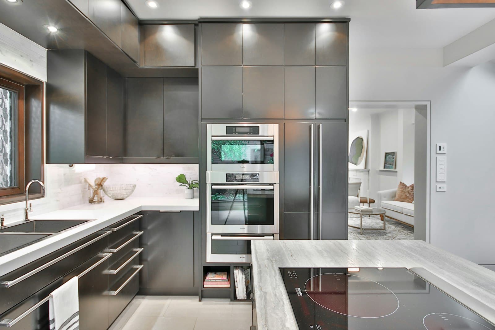 Modern kitchen with stainless steel built-in appliances and marble countertops