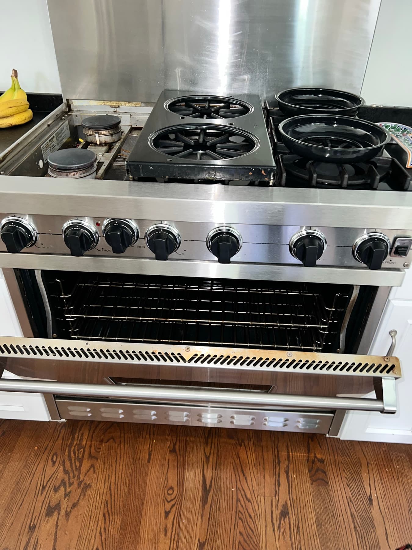 Range with burner grates removed exposing the burner assembly during repair